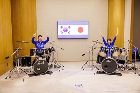 This handout photo taken on January 13, 2026 and released from Japan's Government Public Relations Office via Jiji Press shows South Korea's President Lee Jae Myung (L) and Japan's Prime Minister Sanae Takaichi playing drums, in Nara, Nara Prefecture.