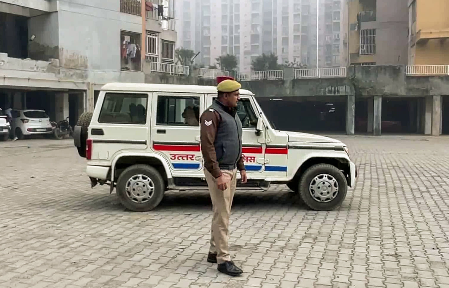 A local police officer at the residential complex in the Loni area where three minor sisters tragically died after falling from the 9th floor, in Ghaziabad on Wednesday.  