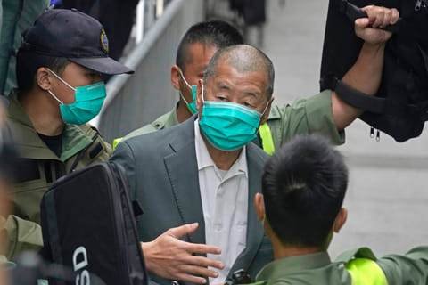 Hong Kong pro-democracy media tycoon Jimmy Lai (C) is led into a police van as he heads to court to be charged under the territory's controversial new national security law in Hong Kong on December 12, 2020, after being accused of conspiring with foreign forces to endanger national security, and could face a lengthy jail term.