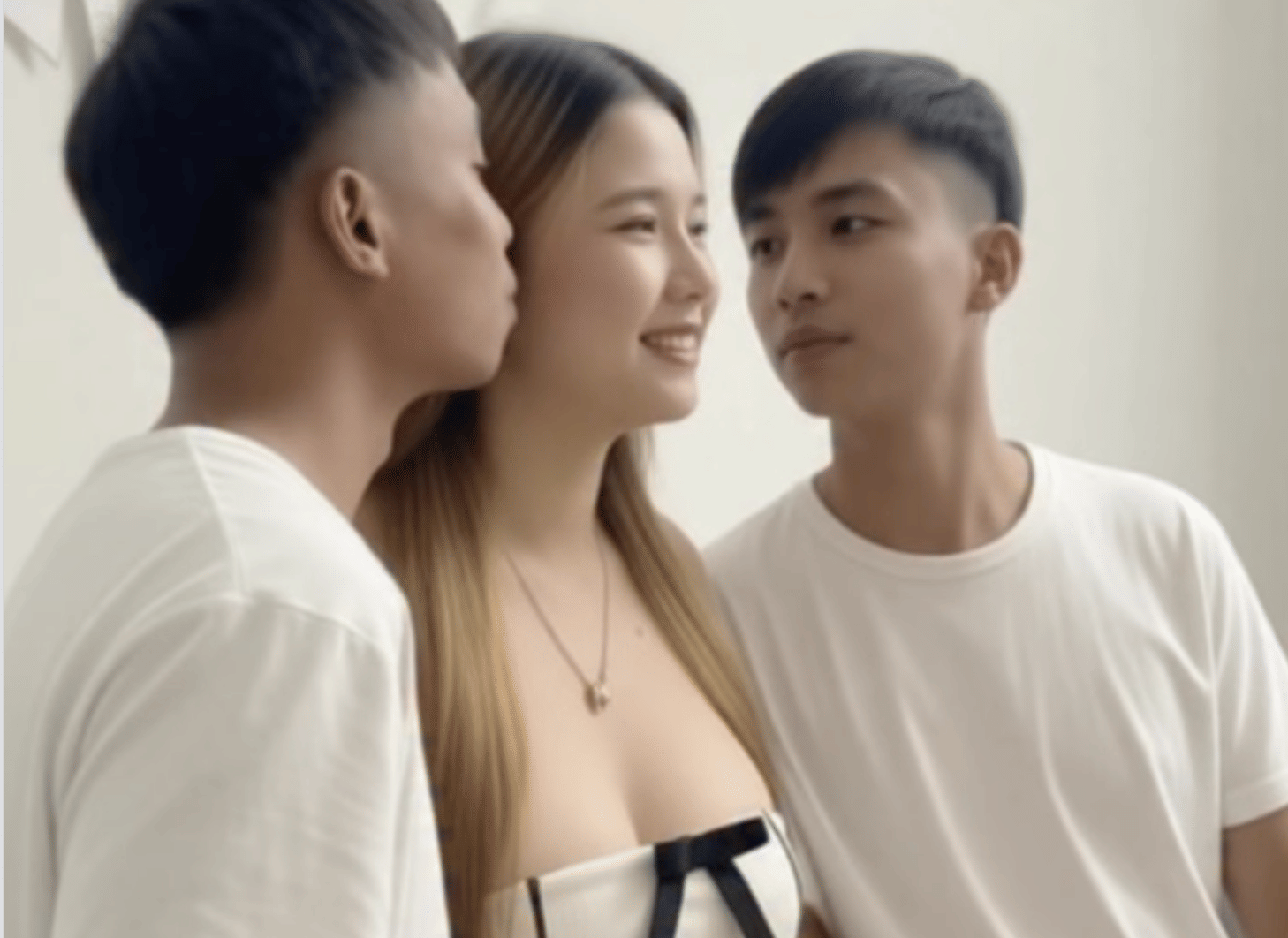 Nong Fah, 24, from Thailand’s Nakhon Phanom province, has social media in a full meltdown after revealing she’s dating both twin brothers Suea and Sing at the same time. One love story, two identical leads — and the internet cannot cope.