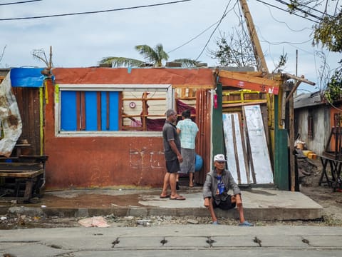 Residents gather near a destroyed house in the city of Toamasina, on the east coast of Madagascar, struck by Tropical Cyclone Gezani on February 11, 2026. At least 38 people were killed, 18,000 homes destroyed.