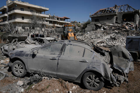 People gather near a building destroyed in an Israeli strike in the village of Bednayel in eastern Lebanon, Saturday, Feb. 21, 2026. (AP Photo/Bilal Hussein)