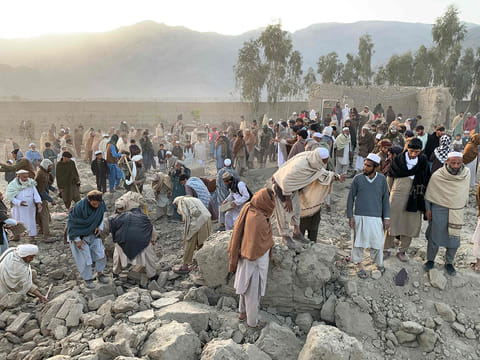 Afghan men search for victims after an overnight Pakistani airstrike hit a residential area in the Girdi Kas village of Bihsud district.