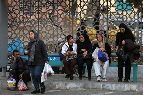 Iranians wait at a bus station in northern Tehran on February 23, 2026.