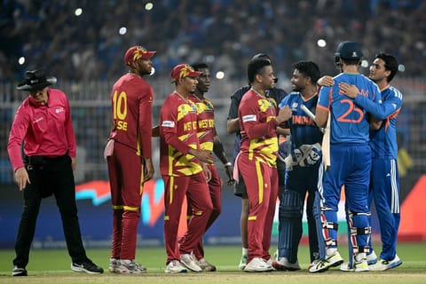 Umpire Alex Wharf gestures as West Indies' Roston Chase, Gudakesh Motie, Shamar Joseph and Shimron Hetmyer congratulate India's Sanju Samson, Shivam Dube and Abhishek Sharma for their team's win at the end of their 2026 ICC Men's T20 Cricket World Cup Super Eights match in the Eden Gardens, Kolkata on March 1, 2026.