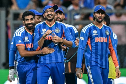 India's Axar Patel (2L) celebrates with teammate Jasprit Bumrah (L) after taking a catch to dismiss England's captain Harry Brook during the 2026 ICC Men's T20 Cricket World Cup semi-final match between India and England at the Wankhede Stadium in Mumbai on March 5, 2026.