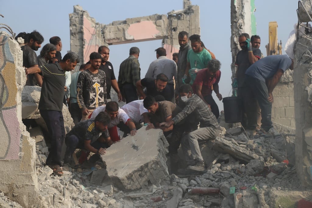 Rescue workers and residents search through the rubble in the aftermath of what Iranian officials said was an Israeli-US strike on a girls' elementary school in Minab, Iran, Saturday, Feb. 28, 2026. 