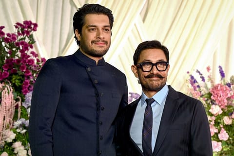 Bollywood actor Aamir Khan (R) and his son Junaid Khan at the wedding reception of Indian filmmaker Sooraj Barjatya’s daughter Eesha Barjatya and Abhishek Kothari in Mumbai on March 12, 2026.