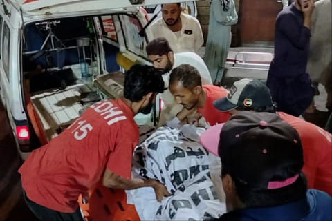 Rescue workers carry the body of a victim who died in an incident due to heavy rain strong winds, upon arrival at a hospital in Karachi, Pakistan, Thursday, March 19, 2026.  