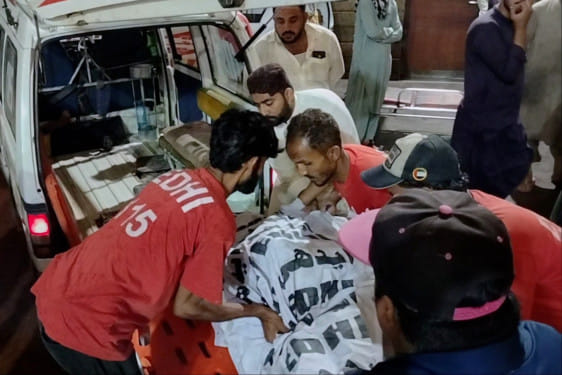 Rescue workers carry the body of a victim who died in an incident due to heavy rain strong winds, upon arrival at a hospital in Karachi, Pakistan, Thursday, March 19, 2026.  