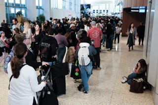 Passengers queue to go through security at New York's LaGuardia airport on March 22, 2026.