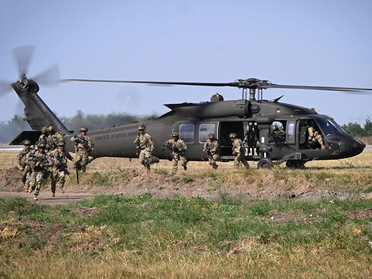 Military personnel of the US Army's 101st Airborne Division leave a helicopter during a demonstration drill at Mihail Kogalniceanu Airbase near Constanta, Romania on July 30, 2022. 