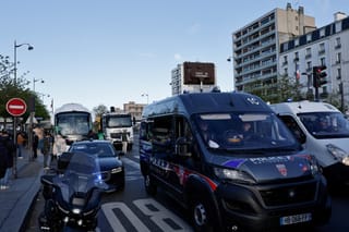 A photo shows parked buses and trucks near police vehicles ahead of a demonstration by lorry and coach drivers to block the city's Boulevard Peripherique ring road, in eastern Paris, on March 30, 2026.