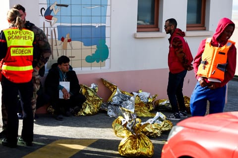 A man sits next to rescue units after an attempt to cross the English Channel illegally turned tragic with several migrants found in cardiac arrest, in France's Pas-de-Calais northern coastal city of Equihen-Plage on April 9, 2026.