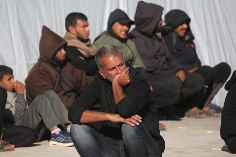 A man sits watching as family members mourn outside the Nasser Hospital, the day after a Palestinian was killed in an Israeli strike in Khan Yunis, in the southern Gaza Strip on April 10, 2026.