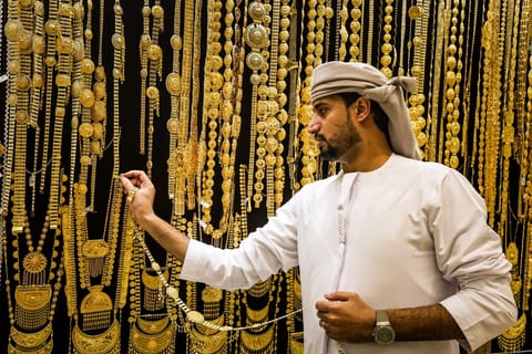 A gold dealer arranges a necklace in a jewellery shop at the Dubai Gold Souk earlier this week.