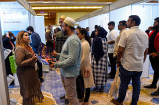 Parents interacting with exhibitors to gather information on courses and universities 