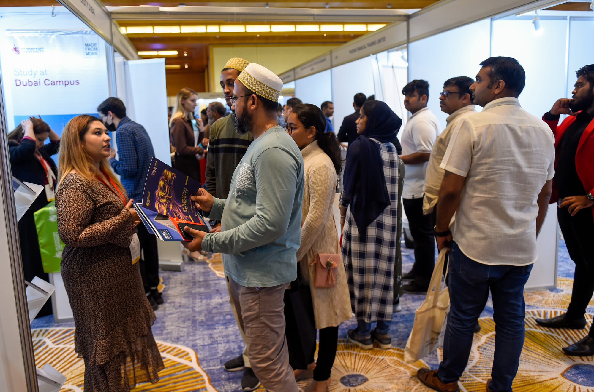 Parents interacting with exhibitors to gather information on courses and universities 