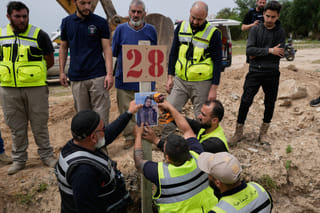 Paramedics attach a portrait over the grave of Ghadir Baalbaki, 19, who was killed on Tuesday in an Israeli airstrike, at a temporary mass grave in the southern port city of Tyre, Lebanon, Wednesday, April 15, 2026.