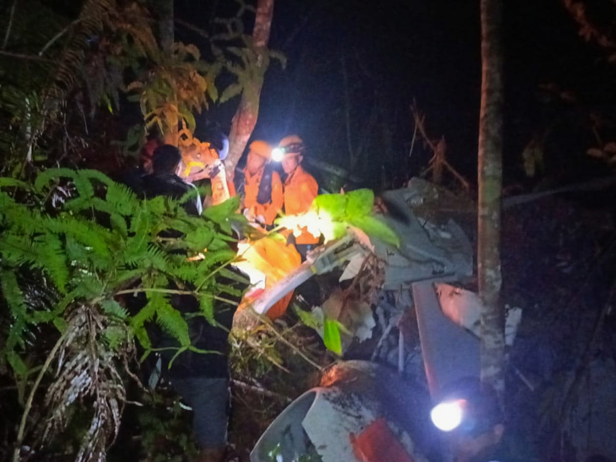Rescuers inspect the wreckage of a helicopter that crashed in Sekadau, West Kalimantan, Indonesia. 