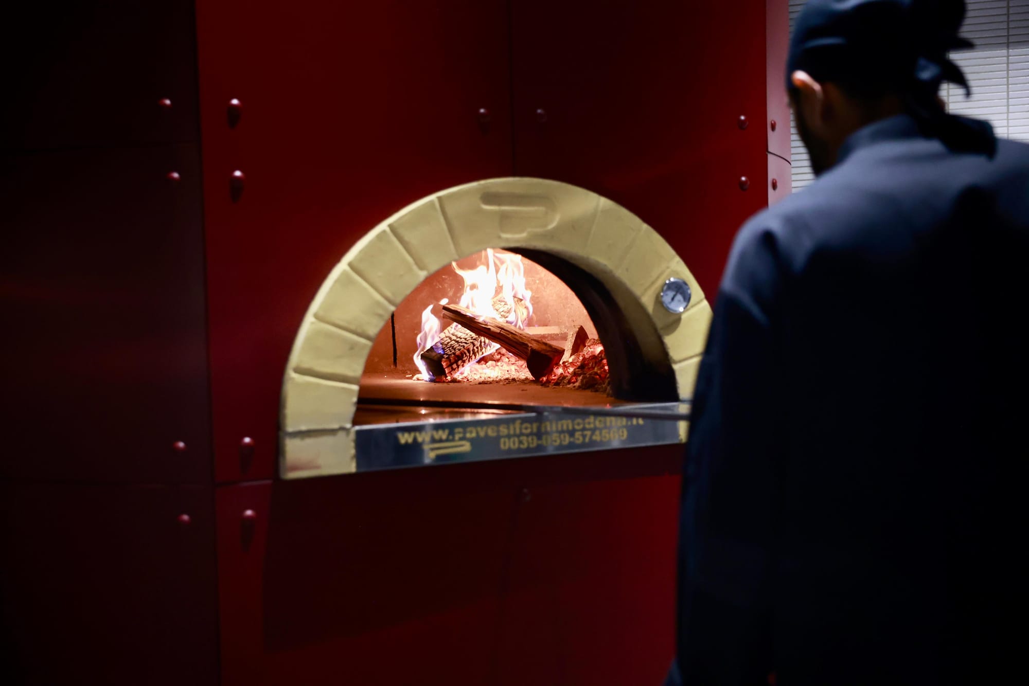 Pizza being made in a wood-fired oven.