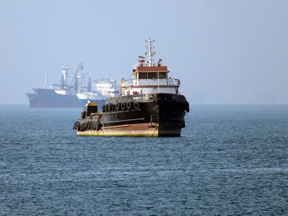 In this picture obtained from Iran's ISNA news agency on May 4, 2026, the Iran-flagged tugboat Basim sails near a ship anchored in the Strait of Hormuz off Bandar Abbas in southern Iran.