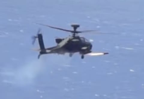 An Apache attack helicopter fires a "Hellfire" missile on a target. 