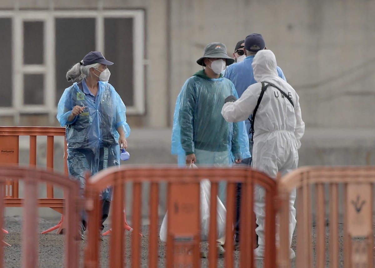 Turkish passengers from the Dutch flagged hantavirus-stricken cruise ship MV Hondius talk to personnel in hazmat suit while disembarking at the industrial port of Granadilla de Abona on the island of Tenerife in Spain's Canary Islands on May 10, 2026.