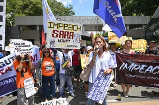 Protesters from progressive groups hold placards during a protest in support of the impeachment of Philippine Vice-President Sara Duterte in front of the Congress building in Quezon City, Metro Manila on May 11, 2026.