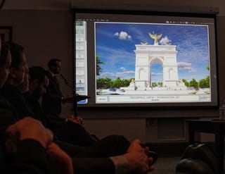 An image of President Donald Trump's proposed triumphal arch to commemorate the country's 250th anniversary is displayed during a public meeting of the Commission of Fine Arts at the National Building Museum on April 16, 2026 in Washington, DC. The Commission of Fine Arts voted unanimously to move forward with a proposed 250-foot arch informally dubbed the "Arc de Trump" that would sit in a roundabout near Memorial Bridge on the Arlington, Virginia side of the Potomac River between Arlington Cemetery and the Lincoln Memorial.