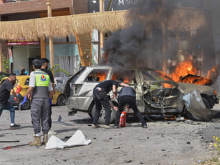 People attempt to extinguish a burning vehicle after an Israeli airstrike hit a car in the coastal town of Barja, south of Beirut, Lebanon