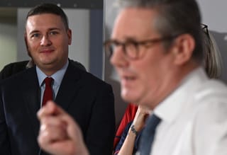 Britain's Health Secretary Wes Streeting (L) listens as Britain's Prime Minister Keir Starmer delivers a speech on a plan to reduce NHS waiting times, during a visit to the South West London Elective Orthopaedic Centre (SWLEOC) in Epsom, south-west of London on January 6, 2025.