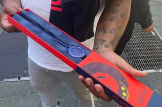 A customer shows his newly purchased Audemars Piguet x Swatch Royal Pop watch outside of a Swatch store in Times Square in New York on May 16, 2026.