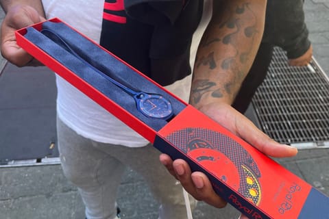 A customer shows his newly purchased Audemars Piguet x Swatch Royal Pop watch outside of a Swatch store in Times Square in New York on May 16, 2026.