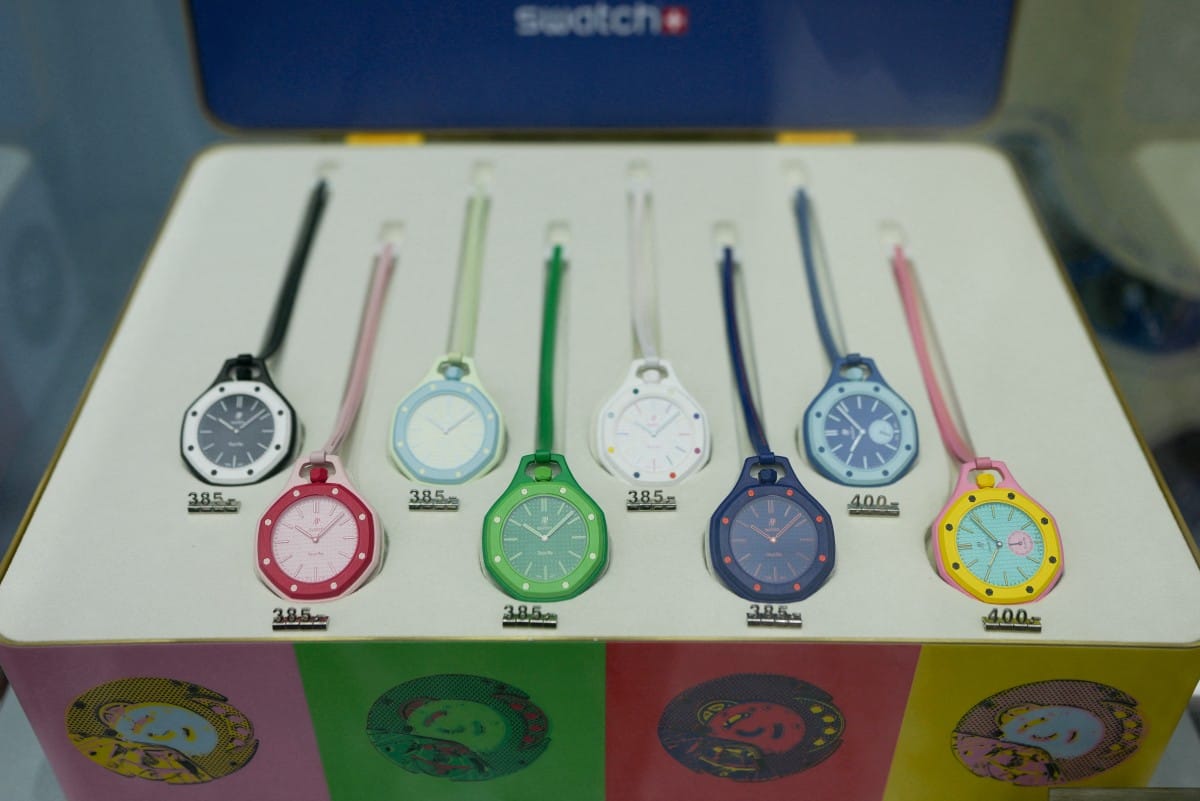 This photograph shows displayed watches of the Royal Pop collection through a glass window on the facade of a closed shop of Swiss watch company Swatch amid a promotional campaign for their watches in partnership with luxury swiss watch maker Audemars Piguet in Paris on May 16, 2026.