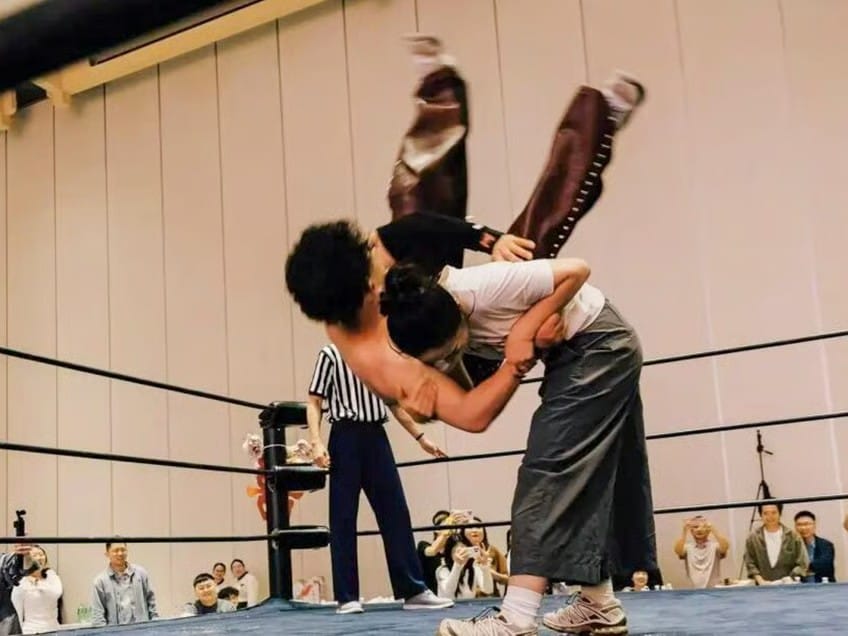 The blushing bride gets the better of her groom as she slams him onto the canvas. 