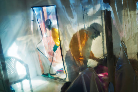 FILE - Health workers wearing protective suits tend to an Ebola victim kept in an isolation tent in Beni, Congo, July 13, 2019. (AP Photo/Jerome Delay, File)