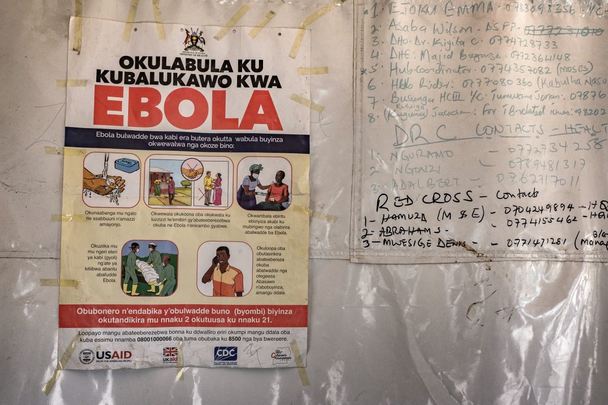 A poster displaying Ebola emergency contact numbers is pinned to a tent at the Busunga border crossing between Uganda and the Democratic Republic of Congo in Bundibugyo, on May 18, 2026.