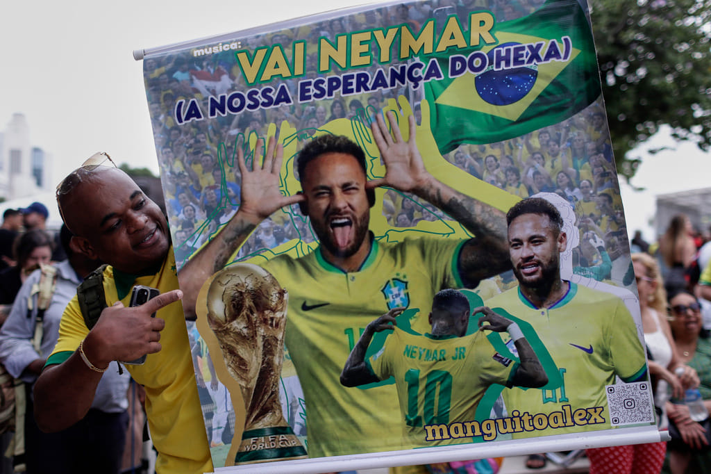 A fan poses with a poster of Brazilian soccer player Neymar, reading in Portuguese "Go Neymar, our hope for a sixth World Cup title" before Brazil's 2026 World Cup squad is announced, in Rio de Janeiro, Monday, May 18, 2026.