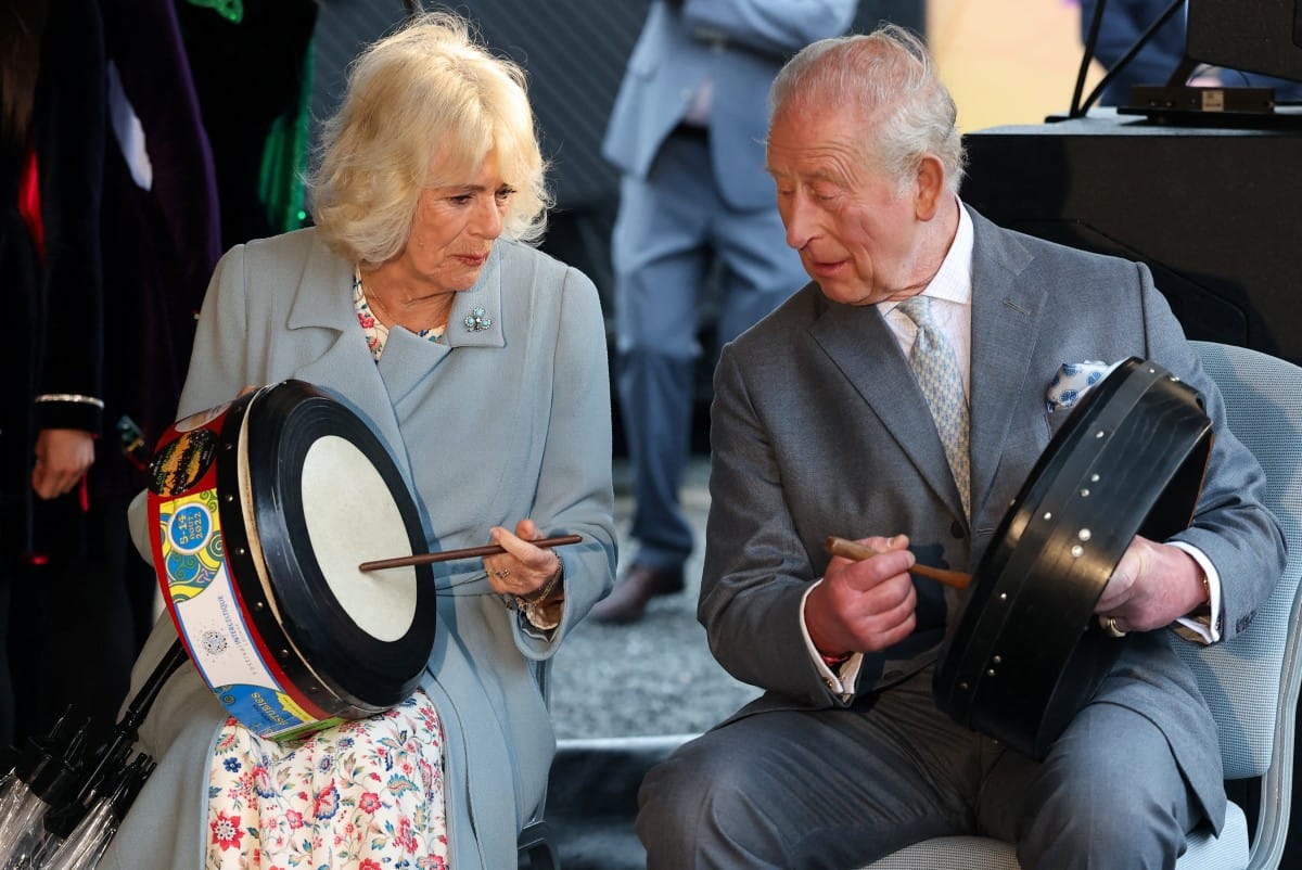 Britain's King Charles III and Britain's Queen Camilla play bodhran drums, traditional Irish drums, as they watch dancers perform to mark Fleadh Cheoil na hÉireann coming to Belfast this August, at Thompson Dock in Belfast, Northern Ireland on May 19, 2026, during their three-day visit to Northern Ireland.
