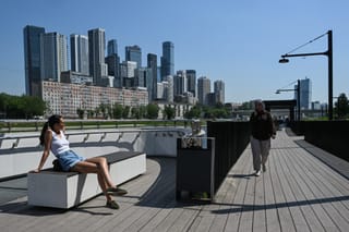 People enjoy hot and sunny weather on the Moskva river embankment in Moscow on May 22, 2026.