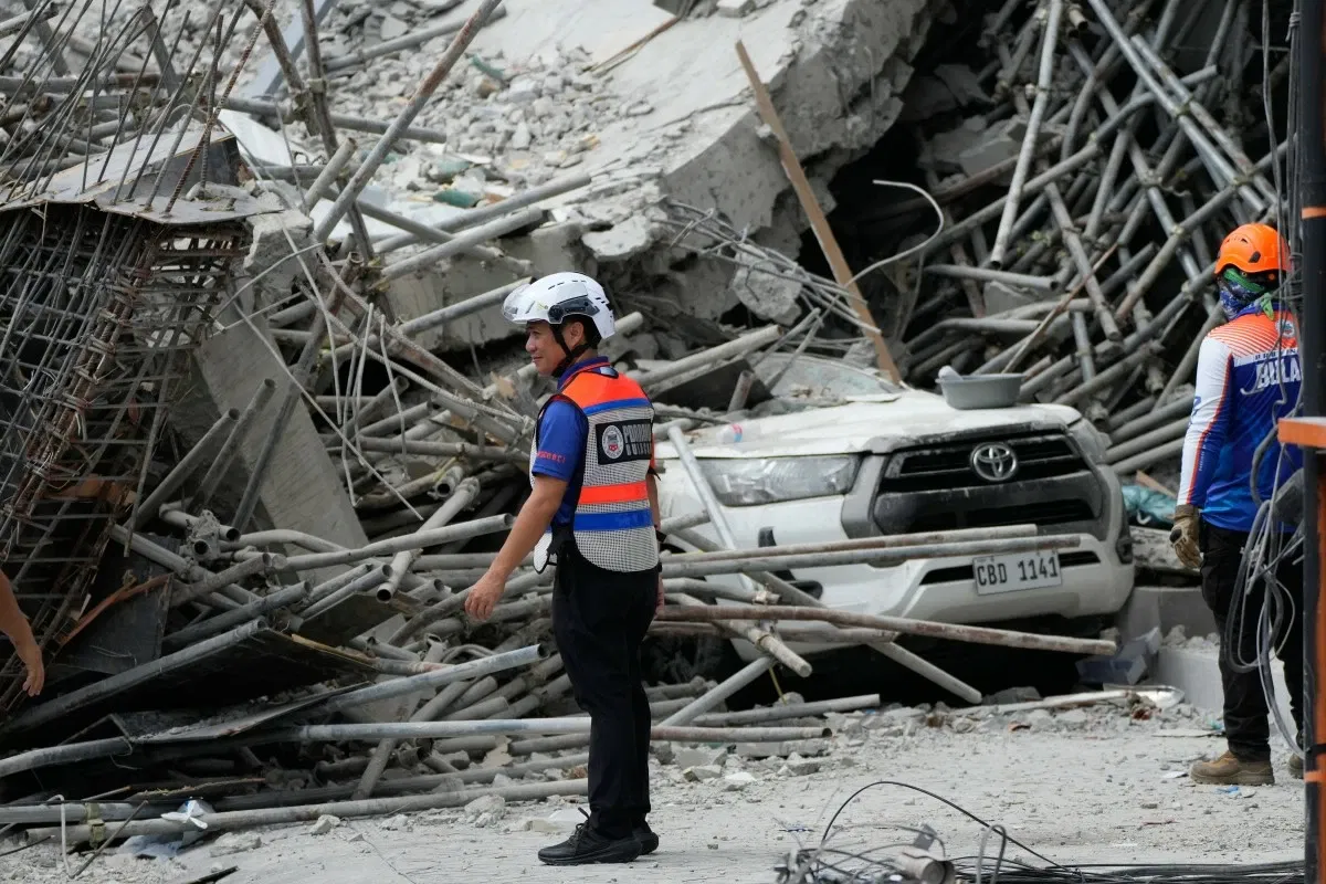 Rescuers stand beside ruins as search operations continue in a collapsed building in Angeles City in Pampanga, Monday, May 25, 2026.
