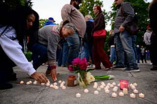 Community members place electric candles near a vase of flowers during a vigil at R.A. Long Park following a fatal chemical storage tank failure on May 26, 2026 in Longview, Washington.