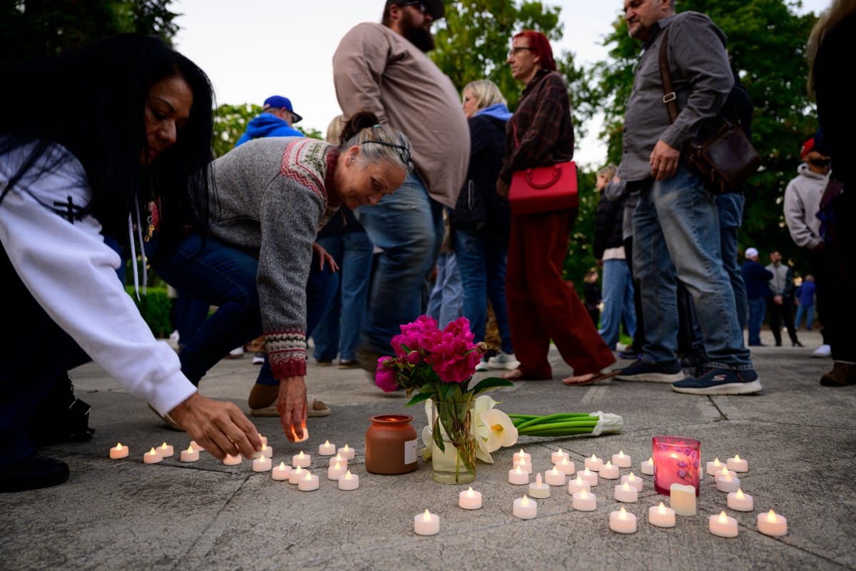 Community members place electric candles near a vase of flowers during a vigil at R.A. Long Park following a fatal chemical storage tank failure on May 26, 2026 in Longview, Washington.