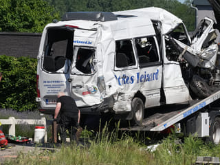 Emergency personnel work at a level crossing to move a van onto a flatbed truck after it collided with a train in Buggenhout, Belgium, Tuesday, May 26, 2026.