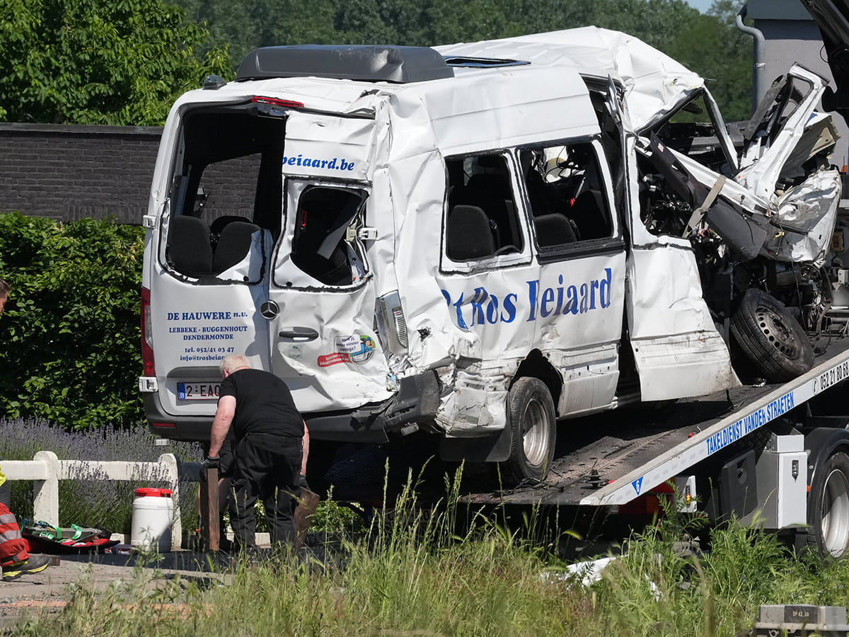 Emergency personnel work at a level crossing to move a van onto a flatbed truck after it collided with a train in Buggenhout, Belgium, Tuesday, May 26, 2026.