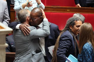 Libertes, Independants, Outre-Mer et Territoires' MP Max Mathiasin (C/R) embraces a fellow MP as his proposed bill aimed at abolishing the slavery-related laws passed unanimously at The National Assembly, France's lower house parliament, in Paris on May 28, 2026.