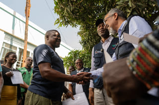 Director General of the World Health Organisation (WHO), Tedros Adhanom Ghebreyesus, right, shakes hands with Ezo Etienne, a health worker who recovered from Ebola in Bunia, Congo, Sunday, May 31, 2026. (AP Photo/Moses Sawasawa)