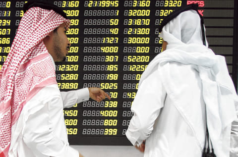 Traders study an electronic share price display at the Doha Stock Exchange in Qatar. The shares of QLM Life & Medical Insurance Co. jumped as they debuted on Qatar's stock exchange on Wednesday.