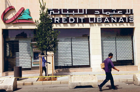 People walk in front of Credit Libanais bank in Beirut, Lebanon. 